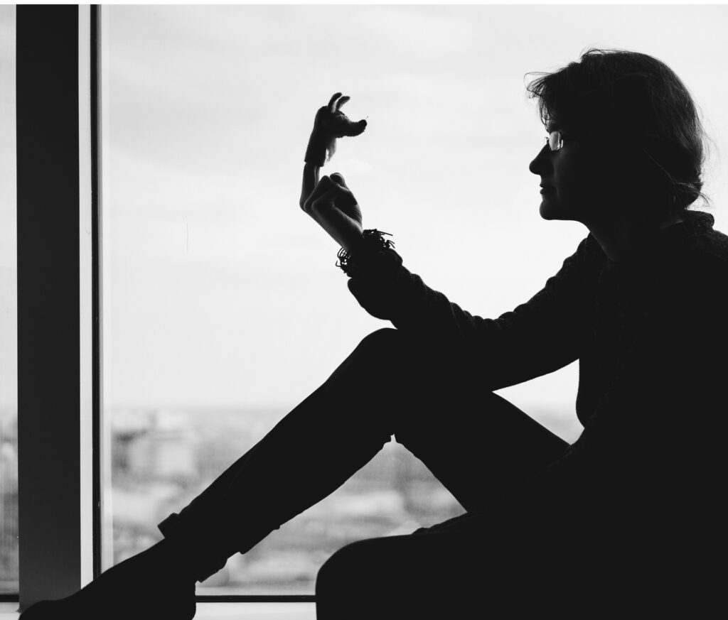 Olga Śmiechowicz, siedząca na&nbsp;parapecie okna